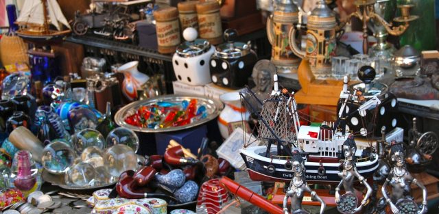 Étal d’objets de collection sur une brocante Étal de brocante garni d’objets de collection : maquette de bateau, boîtes en porcelaine, pièces de monnaie, chopes et figurines