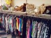 Alternatives à Vinted : les 8 meilleurs sites et applis pour acheter et vendre d’occasion en 2026, frais comparés Portants de vêtements d’occasion et sacs exposés dans une boutique de seconde main