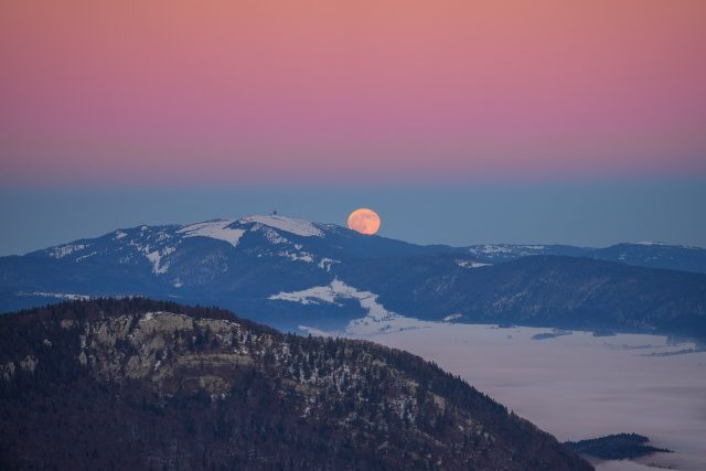 Une pleine Lune qui se lève au coucher du soleil