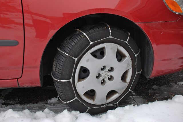 Chaînes à neige montées sur un pneu de voiture Chaînes à neige montées sur un pneu de voiture