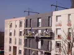 Précarité énergétique : 5 programmes d’aide supprimés en 2027, ce que ça change pour vous Panneaux d’isolation thermique posés sur la façade d’un immeuble en rénovation