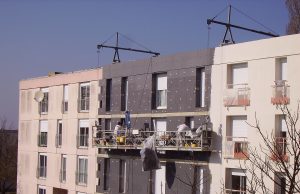 Précarité énergétique : 5 programmes d’aide supprimés en 2027, ce que ça change pour vous Panneaux d’isolation thermique posés sur la façade d’un immeuble en rénovation